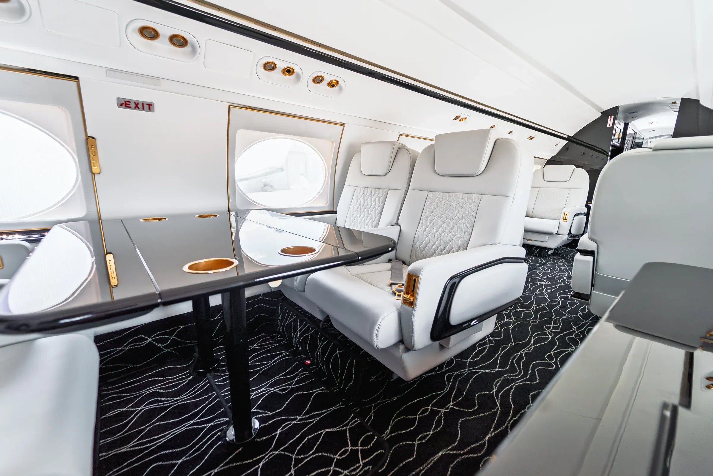 Diagonal view of a Gulfstream G550 club table and white quilted seat.